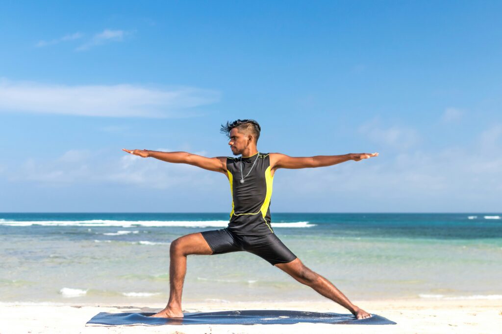 Man doing yoga in front of the ocean